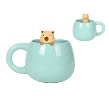 Taza de cerámica verde agua con charm de capibara asomando por el borde.