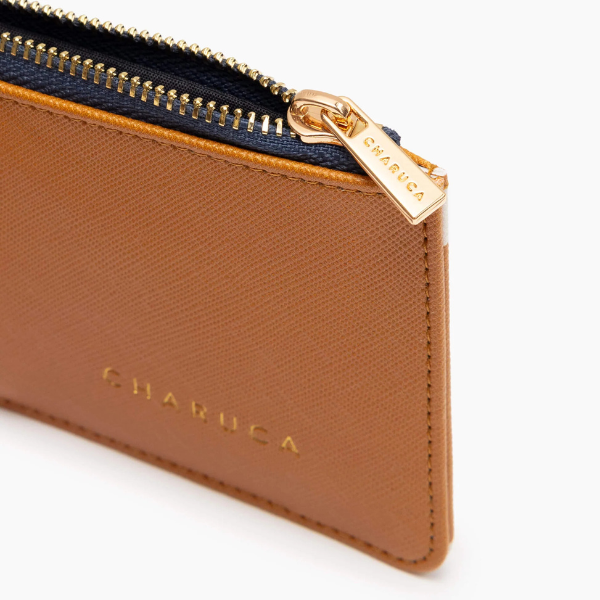 Tarjetero Canela de Charuca Primer plano del grabado “EL DINERO ME AMA” en el tarjetero Charuca.